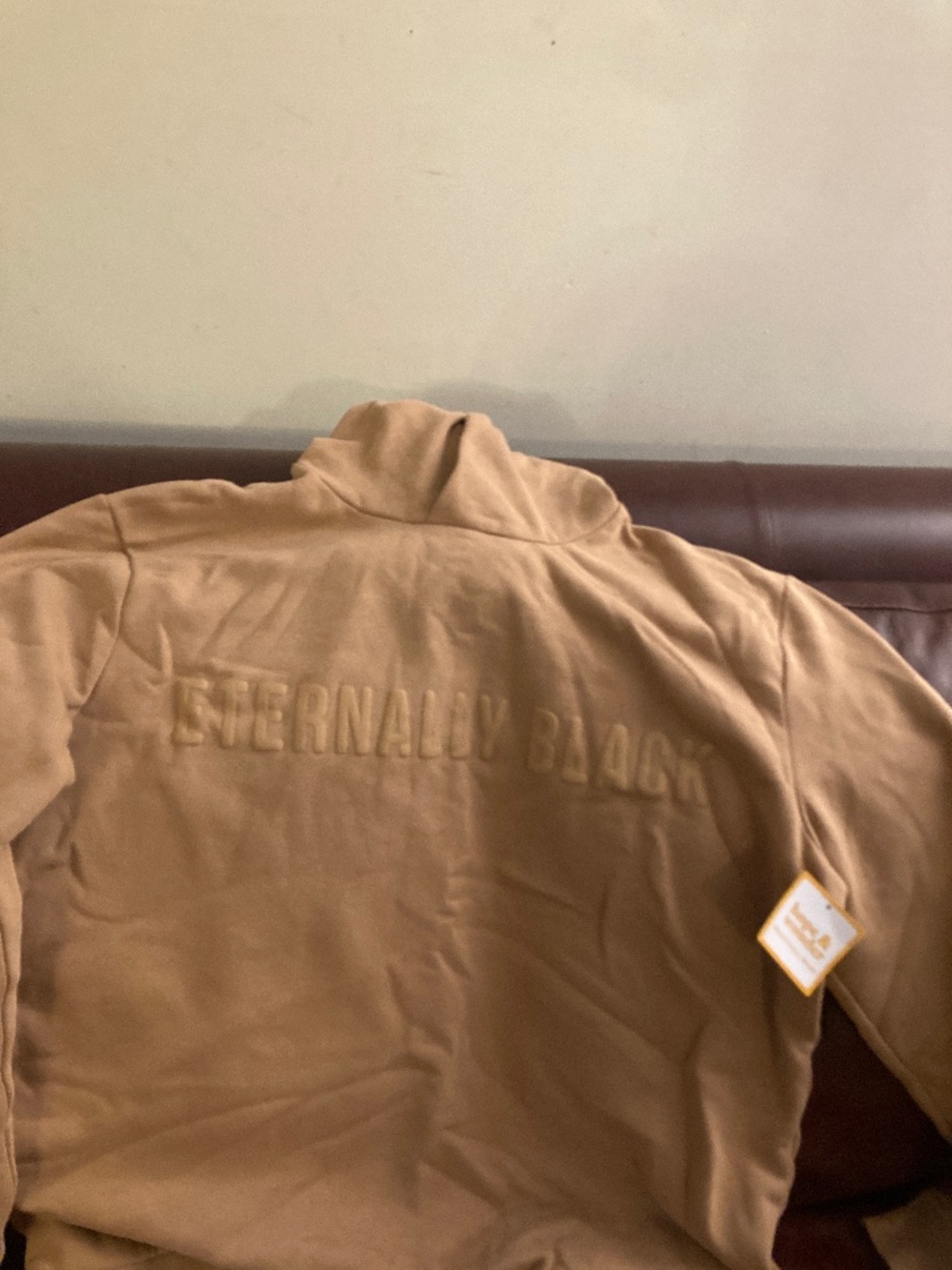 Men’s tan hoodie, says “Eternally Black”